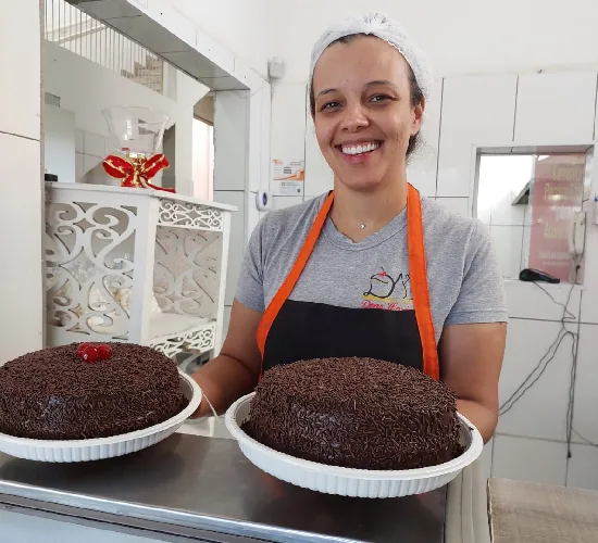 Atendente segurando dois bolos de chocolate