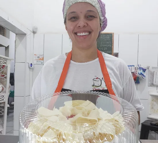 Atendente com bolo de raspas de chocolate branco